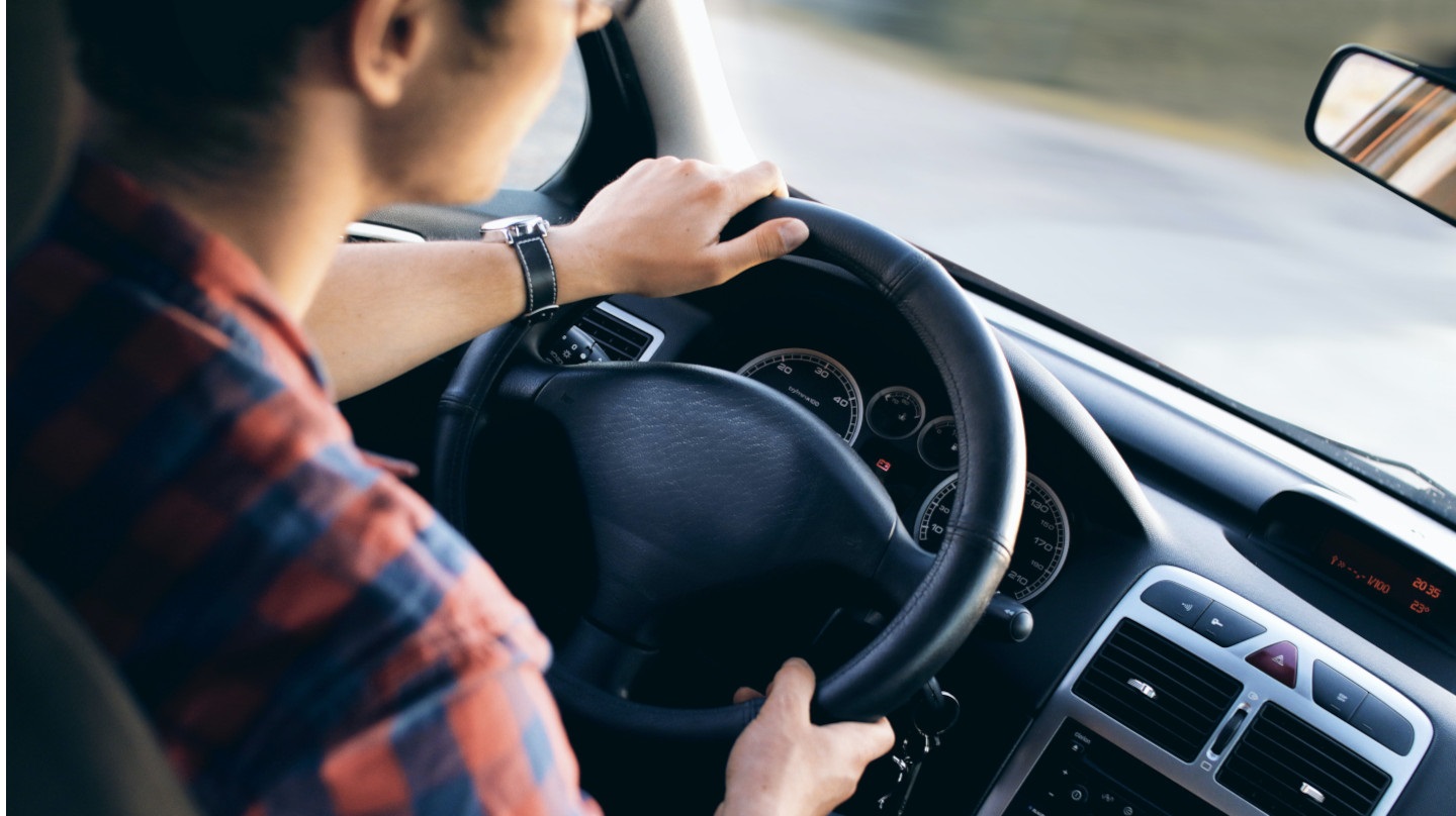 Un jeune homme au volant d'une voiture