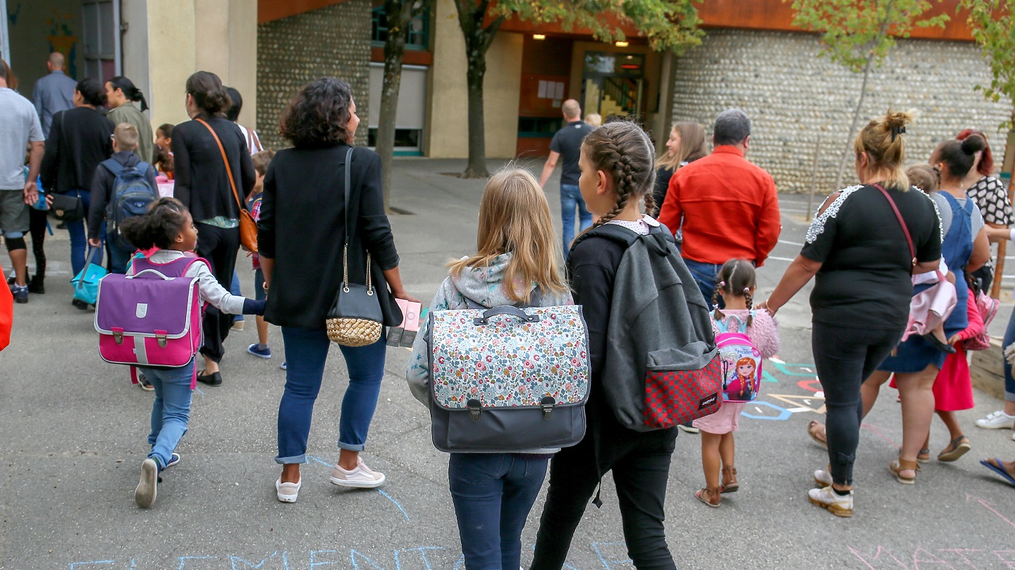 Des parents accompagnent les enfants à l'école.