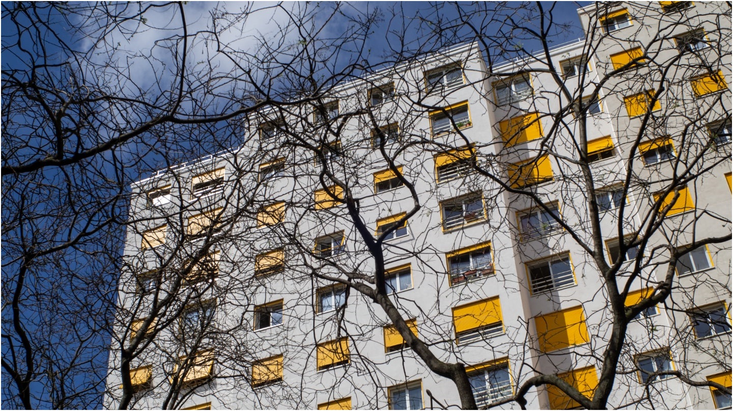 Une vue en contre-plongée d'un immeuble avec des stores jaunes.