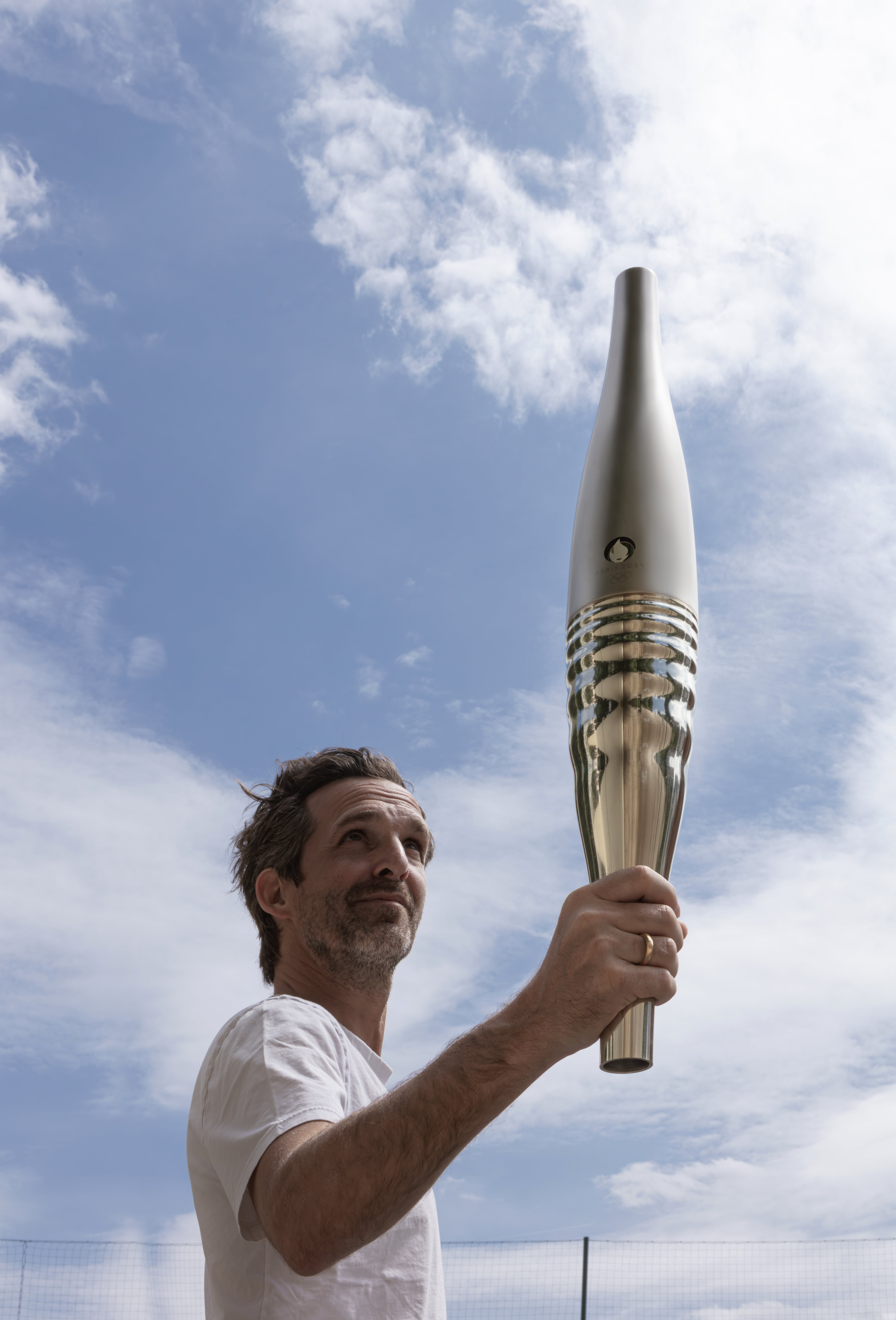 Mathieu Lehanneur portant la nouvelle torche olympique